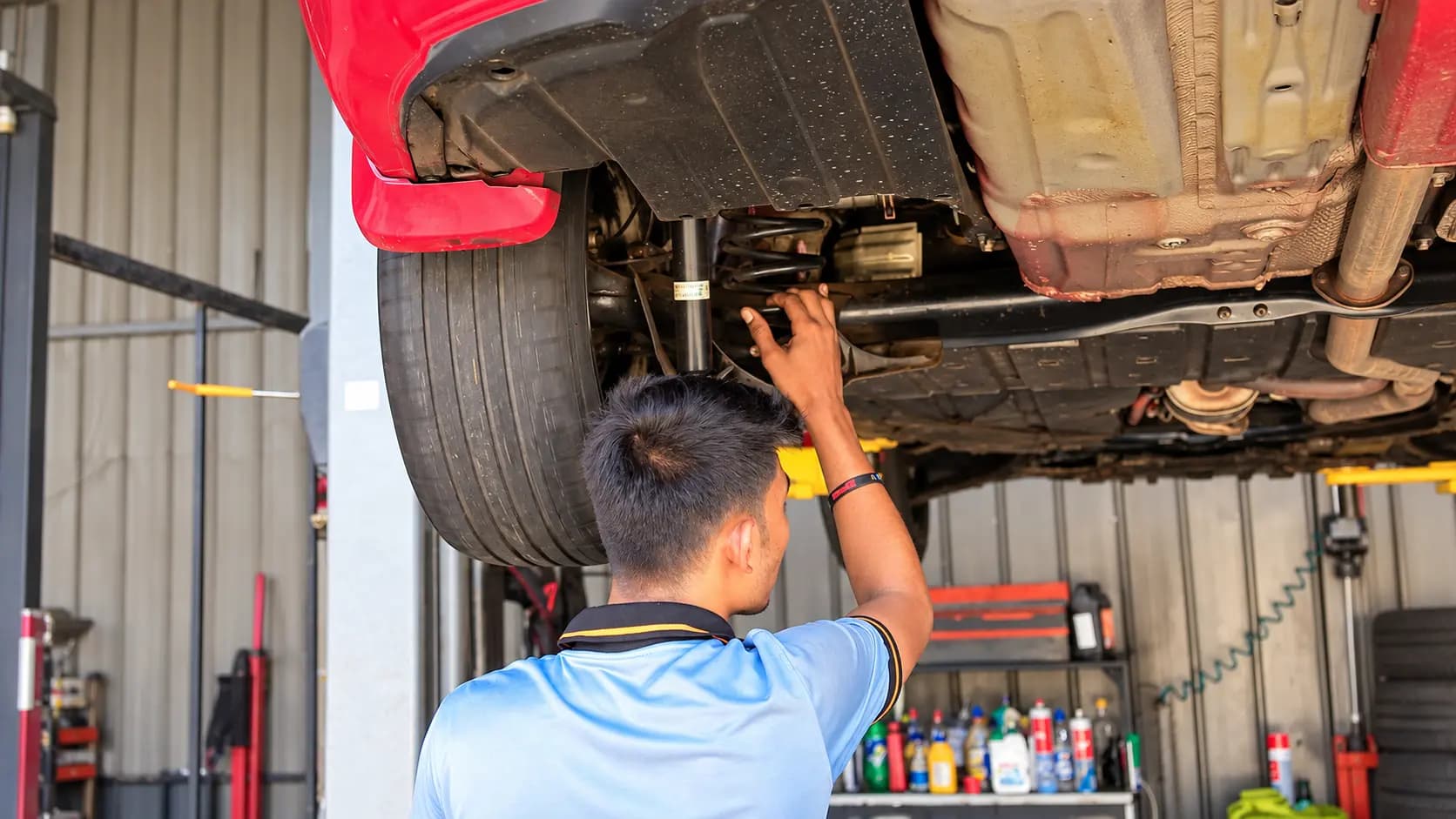EasyCare technician inspecting and repairing a vehicle on a lift